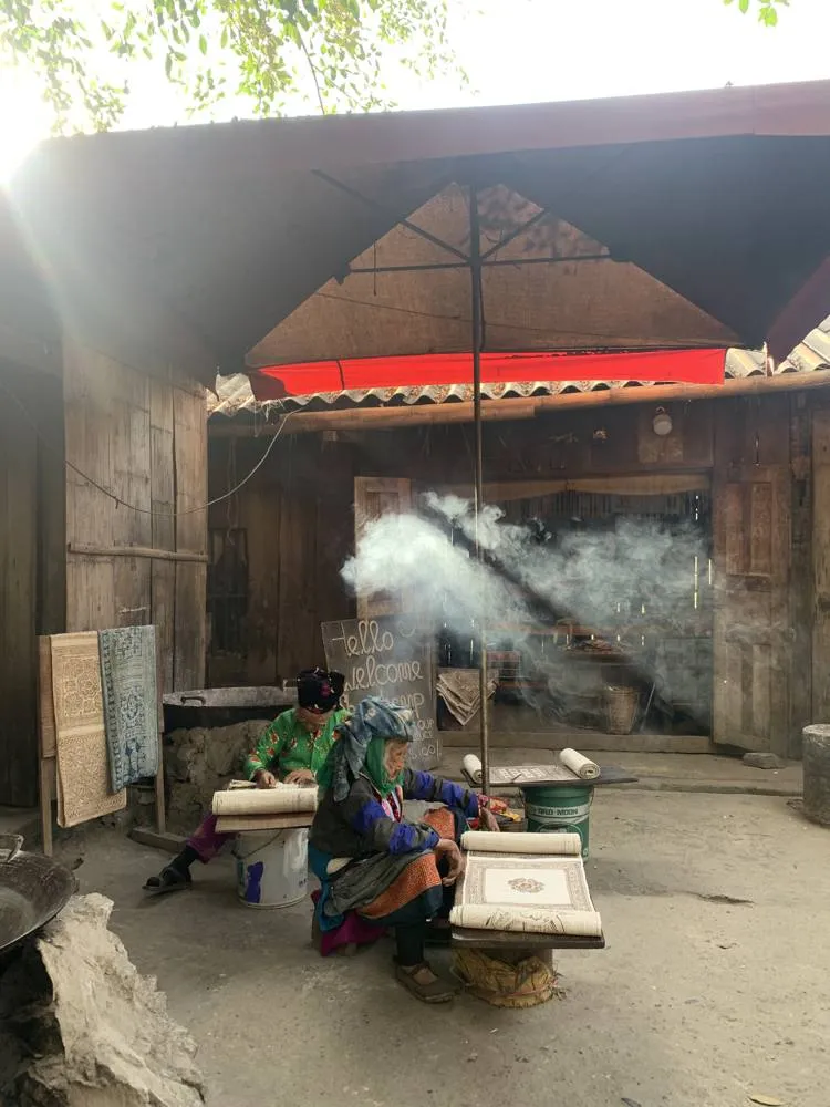 Hmong woman working at a traditional home workshop