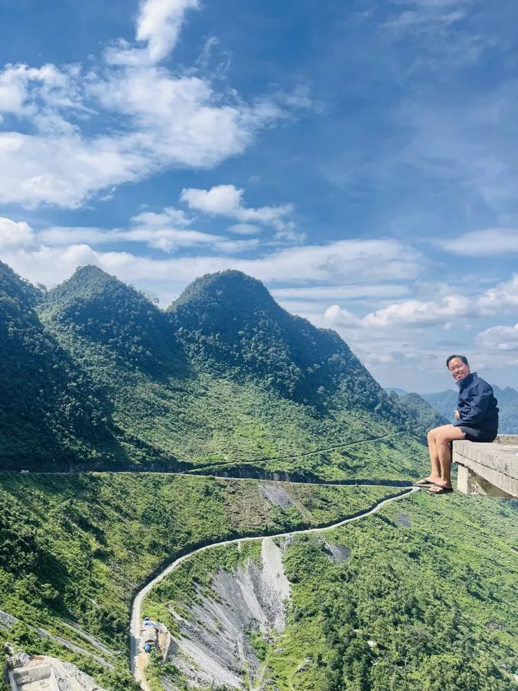 Traveler resting above a winding mountain road
